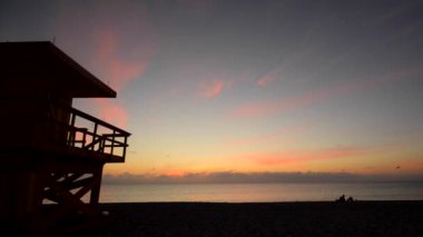 Sunshine over Miami Beach with Lifeguard tower in a typical colorful Art Deco style, Atlantic Ocean in the background. World famous travel location.
