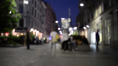 Corso Garibaldi 'nin alacakaranlıkta bulanık insanlarla yürüyüşünü izle..