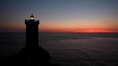 gün batımı deniz sahnesinde deniz feneri bina silueti