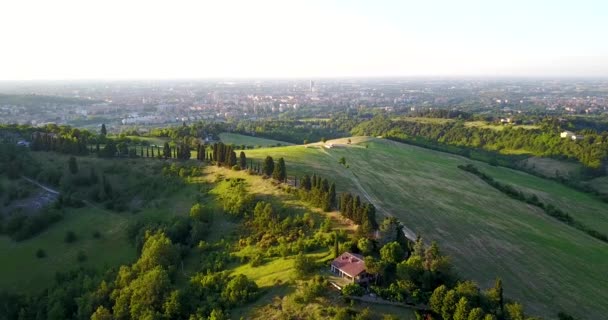 郁郁葱葱的绿色山丘和遥远的山谷村庄的鸟瞰图 — 图库视频影像