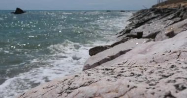 Adriyatik deniz manzarası ve güneşli bir günde kaya. Ön plandaki kayaya odaklan, arka plan bulanık. Pedaso, Marche bölgesi, İtalya.