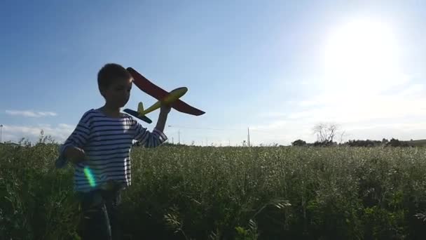 幸せな子供と遊ぶおもちゃの飛行機で空を背景にビーチ — ストック動画