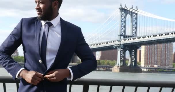 Joven Hombre Negocios Confiado Traje Posando Muelle Fondo Manhattan Bridge — Vídeo de stock