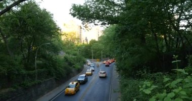 Günbatımında New York 'taki Central Park' tan trafik manzarası. Park, 35 milyon ziyaretçiyle ABD 'de en çok ziyaret edilen şehir parkı..