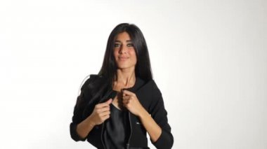 Woman wearing posing  against white wall background. 