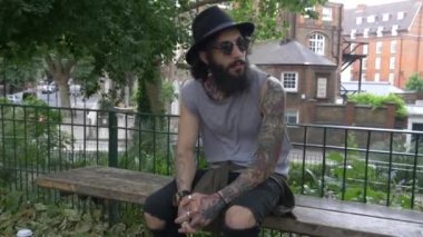 Genç dövmeli adam Shoreditch ilçesini görüntülüyor. Londra, İngiltere. Hipster tarzı
