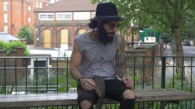 Genç dövmeli adam Shoreditch ilçesini görüntülüyor. Londra, İngiltere. Hipster tarzı