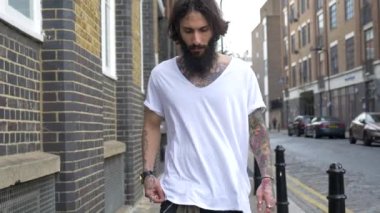 Genç dövmeli adam Shoreditch ilçesini görüntülüyor. Londra, İngiltere. Hipster tarzı