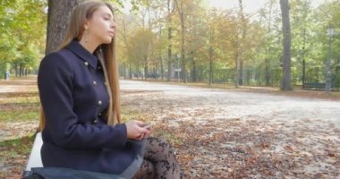 Aut bir parkta genç sarışın kadının gülümseyen yakın portresi