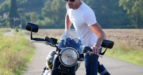 Hombre Deportivo Guapo Usando Motocicleta Blanca Camiseta Entre Prado Día — Vídeos de Stock