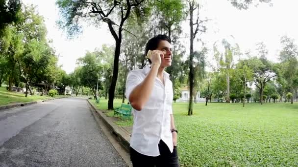 Young Man Walking Park Calling Phone — Stockvideo