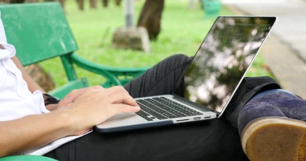 공원에서 벤치에 노트북을 사용하여 남자의 — 비디오