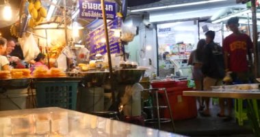 BANGKOK, THAILAND - 13 Kasım 2015: Turistler ve yerel halk, Bangkok 'taki ünlü düşük bütçeli oteller ve pansiyonlar olan Khao San Road' da yemek yiyorlar. 