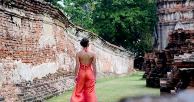 Ayutthaya, Tayland 'da geleneksel tapınağın yakınında yürüyen genç bir kadın.