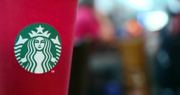 Rode Starbucks Koffie Papier Beker Met Logo Bewegende Mensen Achtergrond — Stockvideo
