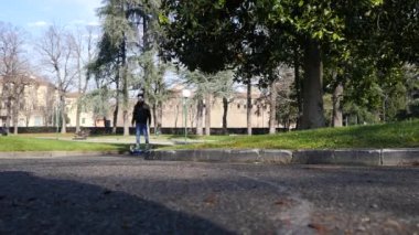 BOLOGNA, İtalya - 31 Ocak 2016: Uçan kaykaydaki genç şarj edilebilir pille çalışan scooter