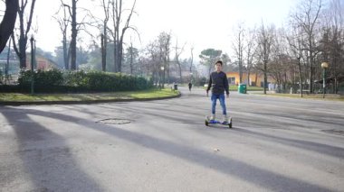 BOLOGNA, İtalya - 31 Ocak 2016: Uçan kaykaydaki genç şarj edilebilir pille çalışan scooter