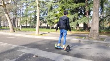 BOLOGNA, İtalya - 31 Ocak 2016: Uçan kaykaydaki genç şarj edilebilir pille çalışan scooter