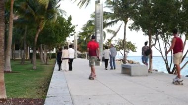 MIAMI BEACH, ABD - 18 Mart 2016: Güneşli bir günde South Pointe Park 'taki gezinti alanında dinlenen, yürüyen ve spor yapan insanlar.