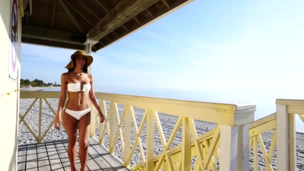 Gyönyörű nő visel fürdőruhát egy pihentető Lifeguard torony i — Stock videók