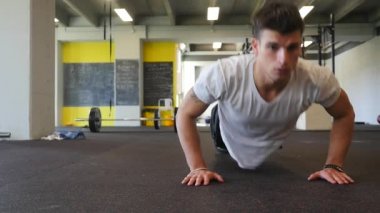 Spor salonunda spor yapan genç bir adam. Etkin bir yaşam biçimi kavramı.