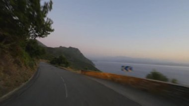 günbatımı gökyüzü altında tepede kıyı yolunun hareketli görünümü