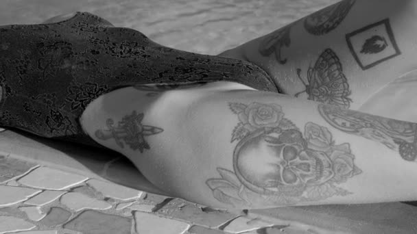 Сексуальна татуйована жінка портрет засмагає на басейні курорту . — стокове відео
