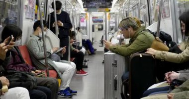 Tokyo, Japonya - Mart, 2017: İnsanlar binerken metro vagonu içinde akıllı telefon kullanıyor. Modern toplumda iletişim eksikliği kavramı. 
