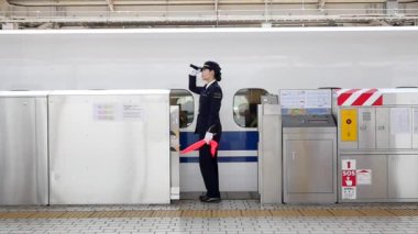 TOKYO, JAPONYAN - CIRCA MARCH, 2017: tren istasyonunda kontrolör. Shinkansen Mermi Treni, yılda 151 milyon yolcu taşıyan dünyanın en işlek tren hattı..