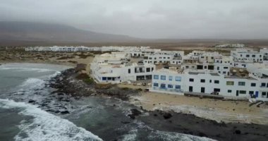 uzak dağlar ve bulutlu gökyüzü ile sahilde haddeleme dalgalar