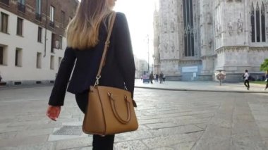 MİLAN, İTALYA - 28 Eylül 2016: Michael Kors çantasıyla sokakta yürüyen genç bir kadın. Michael Kors lüks bir çanta ve kadınlar için aksesuar tasarımcısı. İllüstrasyon Editörü.