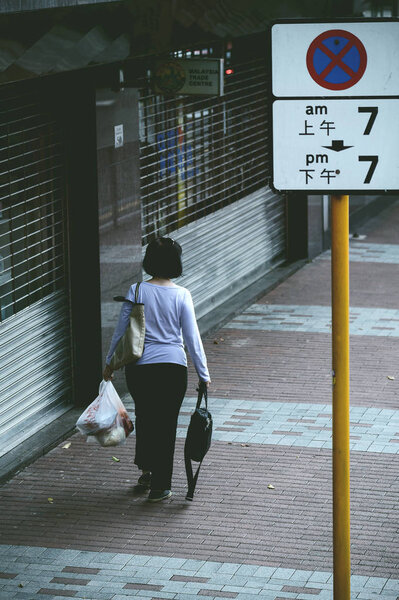 HONG KONG - APRIL 01, 2018 : Woman carrying plastic bag in her hand after shopping at the market.