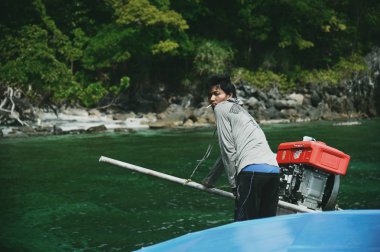 Lipe - Satun, Tayland - 25 Ocak 2018: Adam long tail tekne Lipe Satun, Tayland Adası'nda kontrol ediyor.