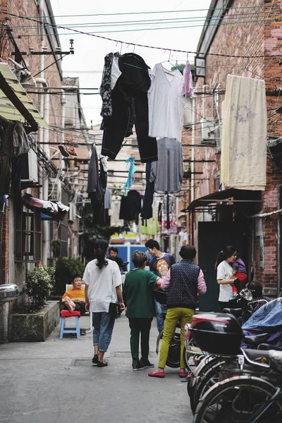 Pessoas falando na frente de sua casa com roupas de secagem — Fotografia de Stock