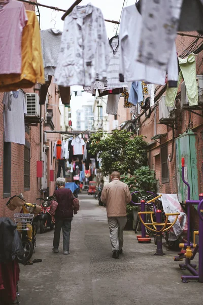 Οι άνθρωποι περπατούν κοντά στο σπίτι τους με στεγνωτήρια ρούχα — Φωτογραφία Αρχείου