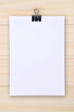 Siyah ataç ve tahta arka planda beyaz kağıt. Macera orada..