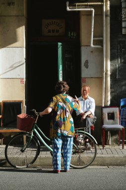 ŞANGHAI, ÇİN - 24 Mayıs 2019: Çin, Şangay 'da Guangdong Yolu' ndaki evin önünde konuşan insanlar.