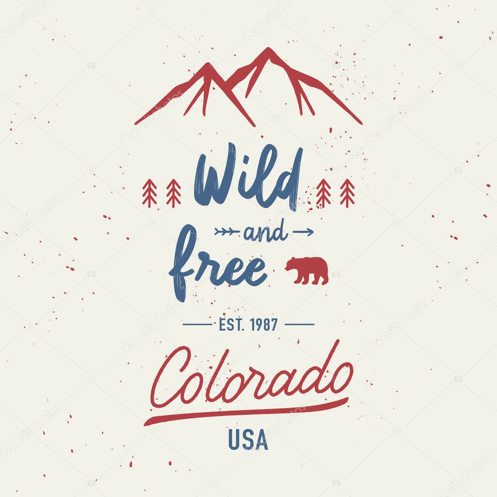 Wild and free with Colorado hand lettering. Travel concept with mountains and abstract watercolor splatters.
