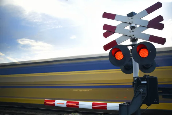 Train railroad crossing with passing high speed riding train