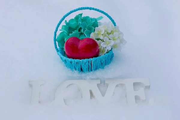 International women day.  March 8 and Valentine\'s day. Basket with flowers on a white snow background. Bengal fire with sparks and beautiful bokeh.