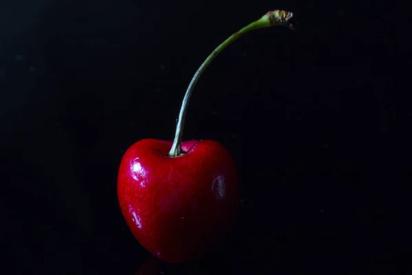 Red cherries with water drops. Cherry on a black background.