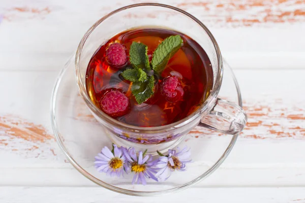 Hot healing black tea with raspberries. Medicinal broth.