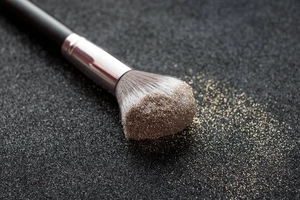 glitter for makeup. Loose gold glitter on the brush for makeup.