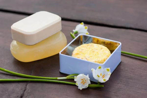 Yığılmış doğal sabun, duş jeli, banyo bomba ve şampuan çubukları koyu ahşap bir masa üzerinde bir renkli seçim. Sıfır için atık, plastik ücretsiz banyo ve ev.