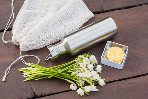 Sıfır atık yaşam tarzı - günlük öğeleri içine bir göz. Eski perdeleri tüm içinde bir katı şampuan ve balsam yeniden kullanılabilir bir teneke kap içinde bir dayanıklı paslanmaz çelik su şişesi repurposed üretmek çanta. Dekorasyon olarak bahar kar taneleri.