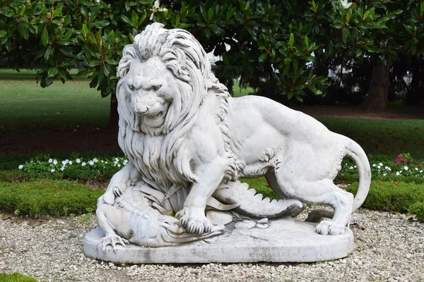 Beyaz Bahçe yeşil arka plana sahip bir timsah saldıran aslan heykeli