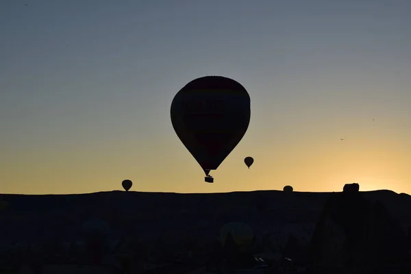 Güzel ve renkli gündoğumu Göreme, Cappadocia hotair balonlar siluetleri ve dağ 