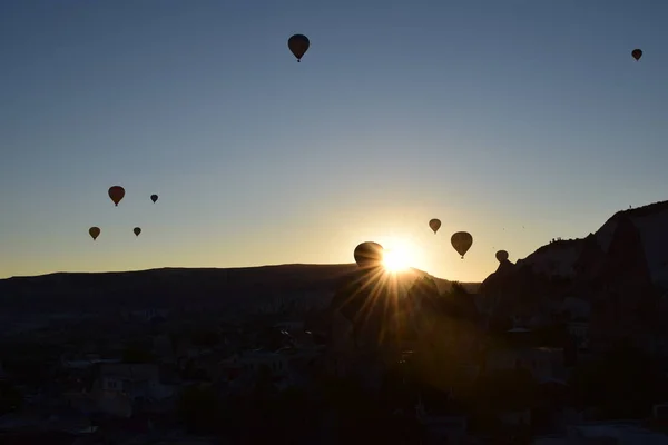 Güzel ve renkli gündoğumu Göreme, Cappadocia hotair balonlar siluetleri ve dağ 