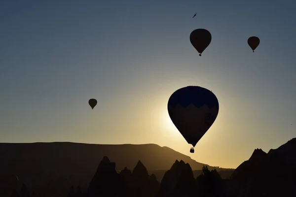 Güzel ve renkli gündoğumu Göreme, Cappadocia hotair balonlar siluetleri ve dağ 