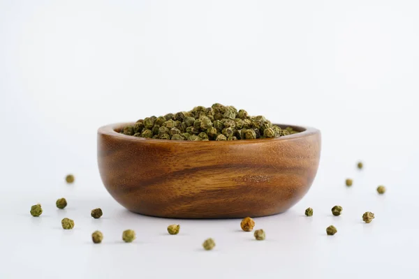 Dried green peppercorns in a wooden bowl